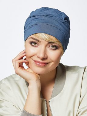 Vrouw draagt een mutsje in een blauwe kleur van Gisela Mayer