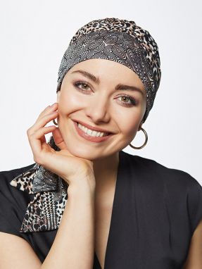 Vrouw draagt een kleurrijk chemo mutsje van Gisela Mayer