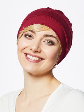 Vrouw draagt een rood mutsje van Gisela Mayer