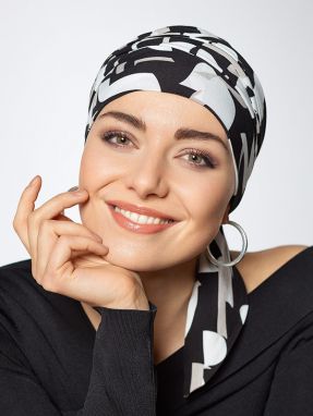 Vrouw draagt een chemo hoofddoekje in het zwart-wit van Gisela Mayer