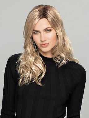 Vrouw draagt een lang blond haarwerk met een lichte slag
