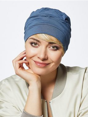 Vrouw draagt een mutsje in een blauwe kleur van Gisela Mayer